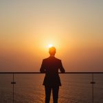 lucid-origin_man_standing_balcony_ocean_horizon_sunrise_suit-7
