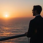 lucid-origin_man_standing_balcony_ocean_horizon_sunrise_suit-6